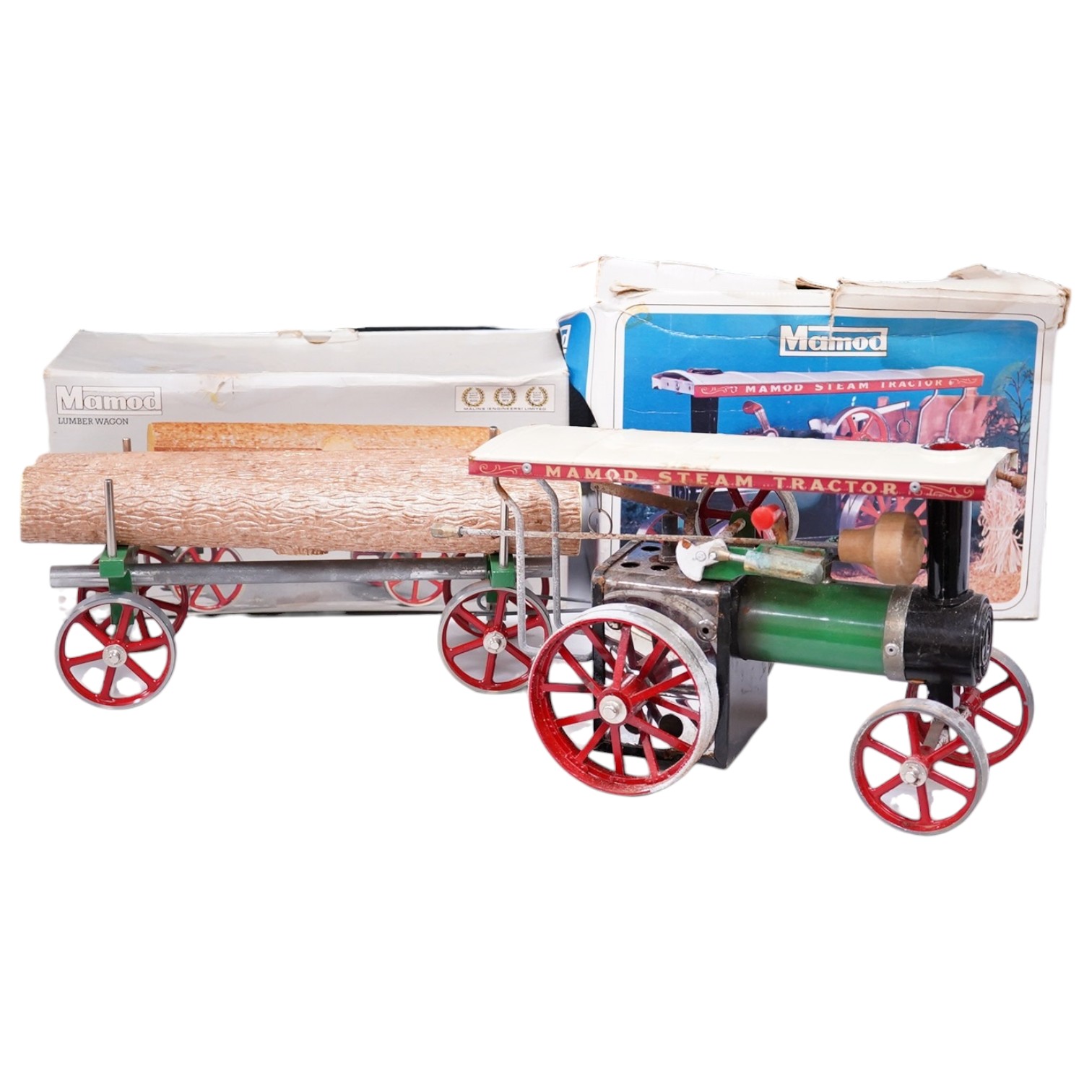 A boxed Mamod TE-1A live steam traction engine and lumber wagon. Condition - poor to fair, there is corrosion to the exposed aluminium and other metal parts.